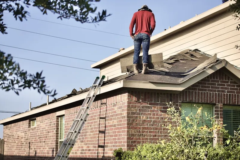 Professional roofer working on a residential roof in Coloma